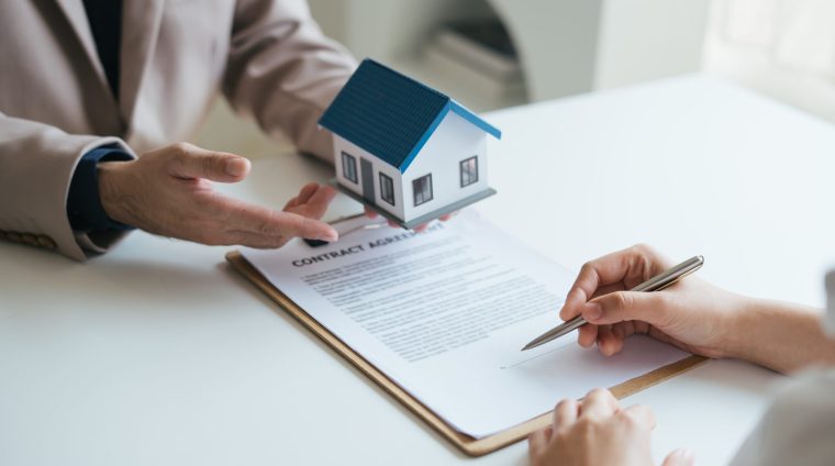 Real estate agent and realtor general liability insurance businessman professional discussing and consultant with house toy model building before sign a contract with law concept.